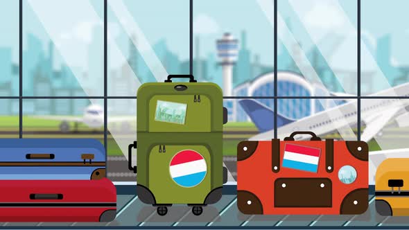Suitcases with Flag of Luxembourg Stickers on Carousel in Airport alt