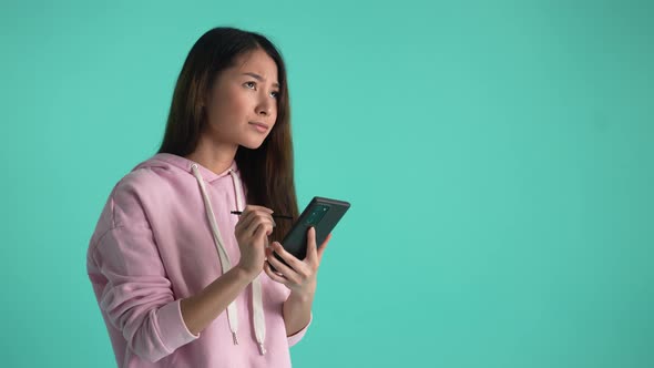 Creative Asian Girl with Phone Thinking Over Idea alt