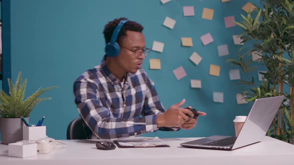 African American Man Using Joystick on Laptop to Play Video Games alt