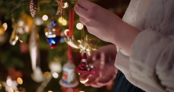 Woman Decorating Beautiful Christmas Tree in Living Room alt