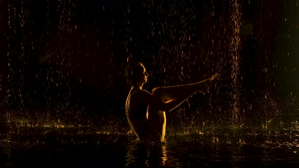 Ubhaya Padangusthasana Performed By a Flexible Woman. The Rain Pours on the Half-naked Body of the alt