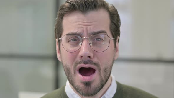 Close Up of Face of Young Businessman with Shocked Expression alt