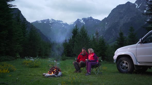 Couple Chatting By Bonfire in a Camping in a Dark Mountain Valley