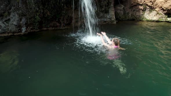 Woman Swimming Towards Secret Waterfall
