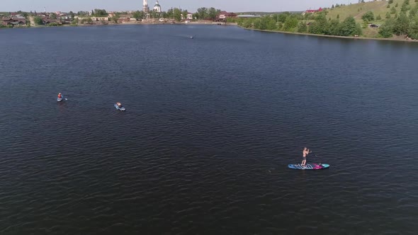 Aerial view of people Stand Up Paddling on pond in provincial city 21 alt
