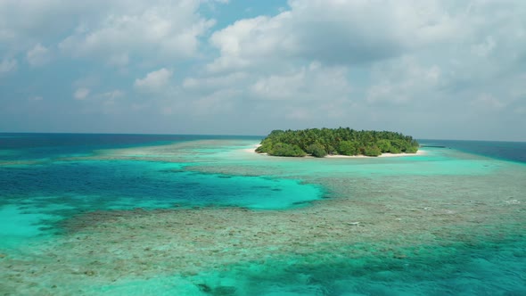Drone flight over the ocean, coral reef, to a tropical island with a white coral beach alt