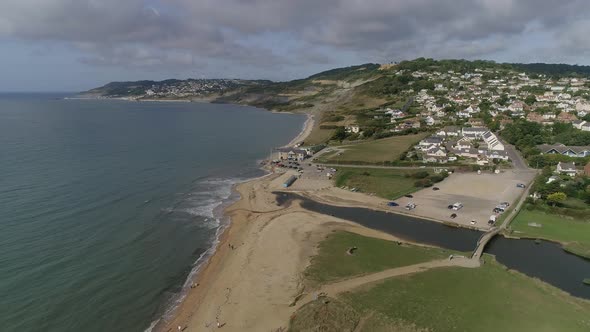 Aerial of Charmouth, Dorset. Facing west, tracking forward and straight. Home of UK fossil hunting. alt
