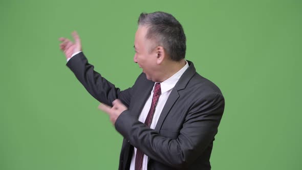 Mature Japanese Businessman Showing Something alt