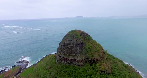 Aerial view rising over a small island and camera pans down for an overhead alt