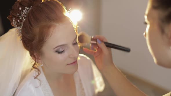 Wedding Makeup Artist Making a Make Up for Bride in Veil. Beautiful Sexy Model alt