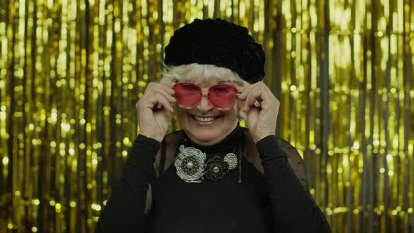 Elderly Stylish Grandmother. Caucasian Woman Posing on Golden Background alt