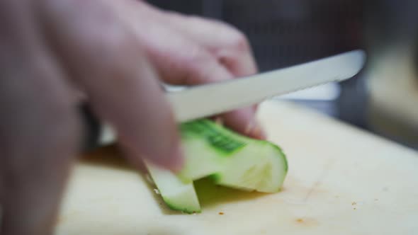 Close Up View of Knife Cutting Cucumber Pieces Into Small Cubes alt