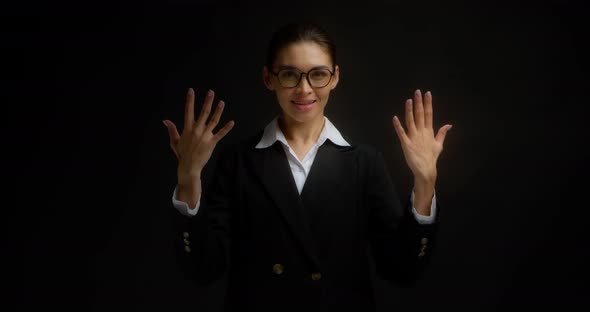 Business Woman Smiles at the Camera and Shows the Number Ten with Her Fingers