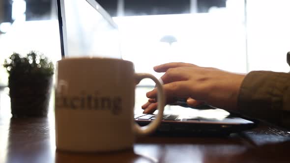 Close up hand old man using laptop typing working in cafe. alt