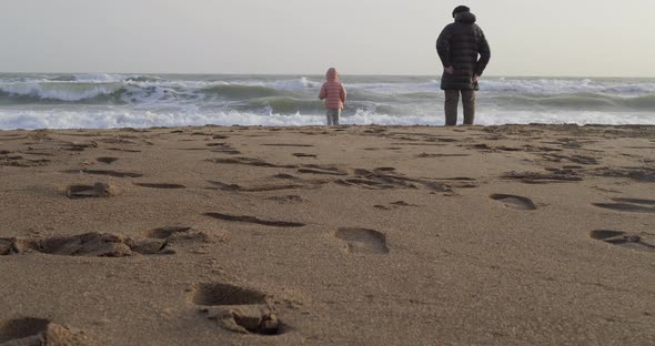 Young Girl Playing By the Sea with Her Grandfather