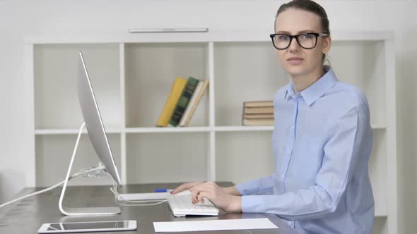 Thumbs Up By Working Woman While Looking at Camera alt
