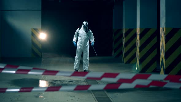 Person in Hazmat Sprays Room During Sanitation. alt