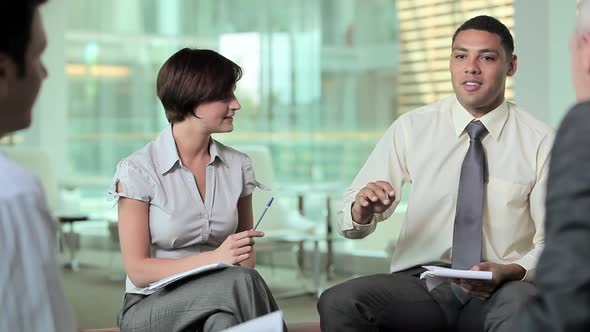 Businessman talking to colleagues in meeting alt