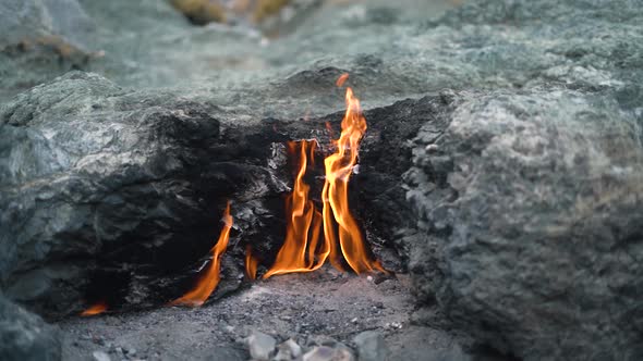Bright Flame Burns Among Grey Rocks on Yanartas Mountain alt