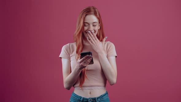 The Young Woman Shocked By a News Item on the Phone with Her Mouth Open Looks Amazed in the Room She alt
