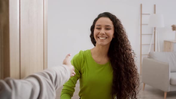 Happy Woman Opening Door And Shaking Hands With Businesswoman Indoor alt