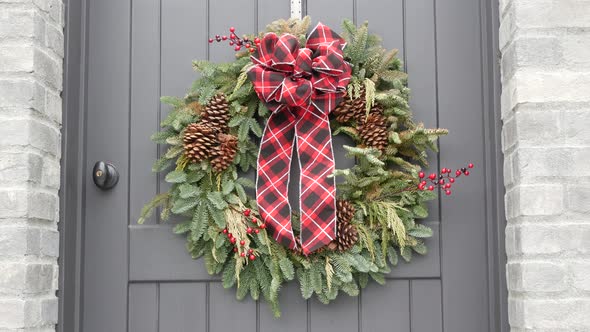 Green Christmas Wreath From Pine or Fir and Red Ribbon on Door New Year Decor