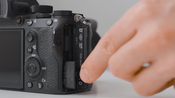Man installing and ring a memory card. Cameras and photography. Close up alt