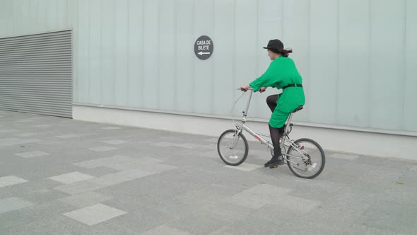Riding a bike and passing by a building alt
