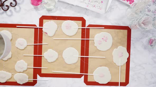 Flat lay. Pouring caramelized sugar on silicone mats to make homemade lollipops. alt