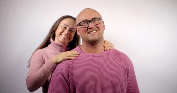 Happy Brunette Woman Is Hugging Her Husband From Back and Smiling Broadly, Portrait of Happy Family alt