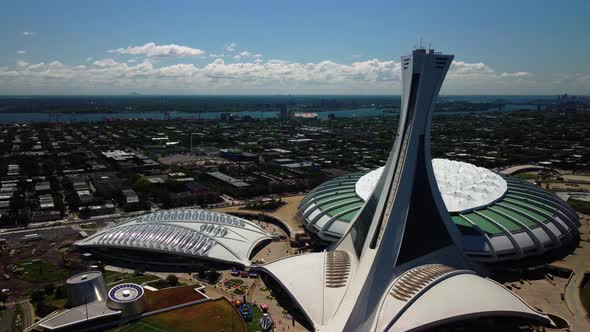 A close drone shot of Olympic Stadium and Biodome in Montreal with St-Lawrence river, during summer alt