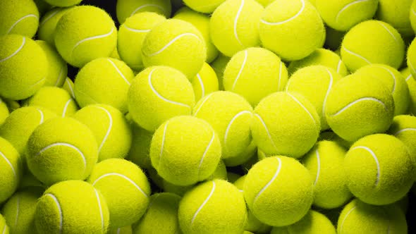 Seamless looping animation.Set of many tennis balls on the black background. alt