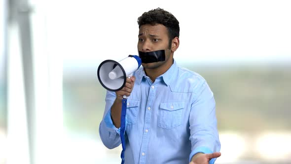 Expressive Man with Taped Mouth Trying To Speak. alt