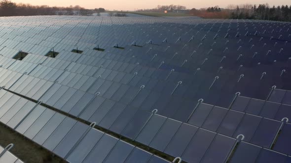Drone Over Blue Solar Panels In Rows And Rows In Countryside alt