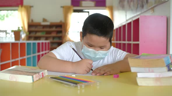 Back to School, Asian little child with face mask doing homework at school