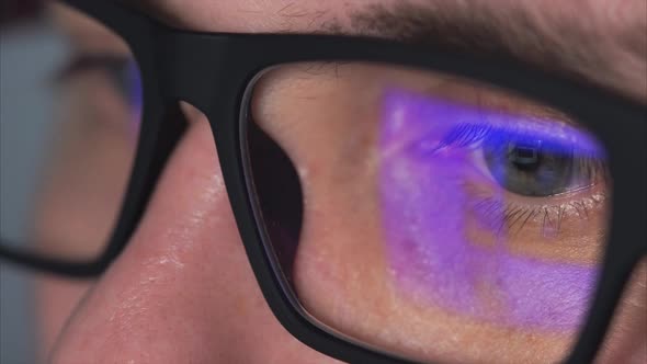 Close Up Shot of a Man's Eyes with Glasses Who Looks at a Computer Monitor alt