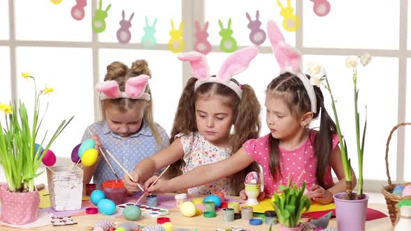 Happy Children Wearing Bunny Ears Painting Eggs on Easter Day