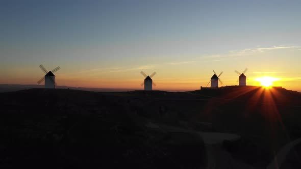 Aerial view of windmills in the countryside in Spain at sunrise alt