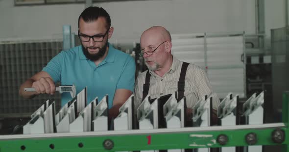 Manager with Engineer Consult While Examine Plastic Window Frames with Calipers alt