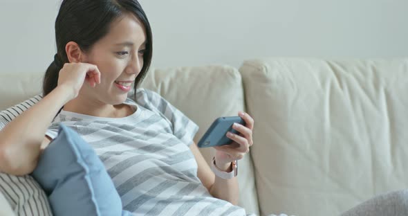 Woman Use of Mobile Phone and Sit on Sofa at Home