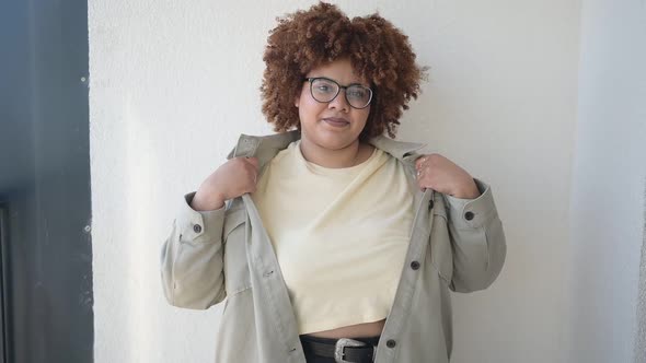 Beautiful Happy Smiling Curvy Plus Size African Black Woman Afro Hair Posing in Beige Tshirt Jeans