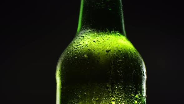 Close Up Green Beer Bottle Rotation in Dark