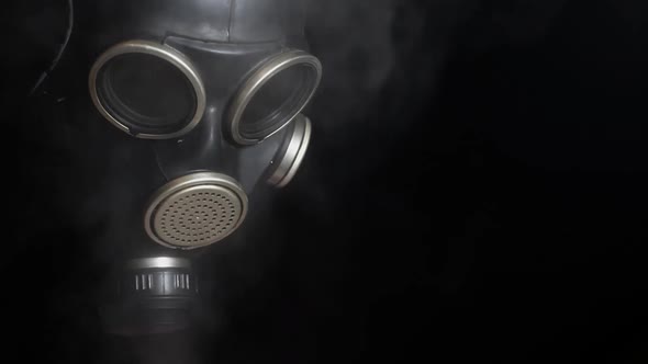 footage of gas mask smoke dark background alt
