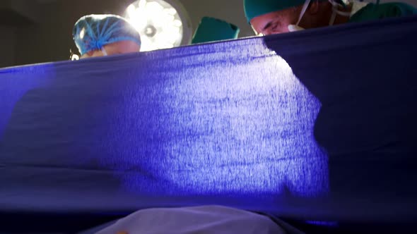 Medical team examining pregnant woman during delivery alt