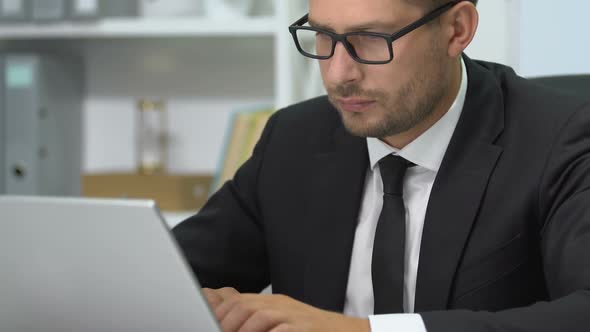 Exhausted Entrepreneur Working on Laptop, Taking Off Glasses, Massaging Nose