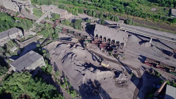 Excavator Loading Crushed Stone Into a Dump Truck in a Crushed Stone Quarry alt