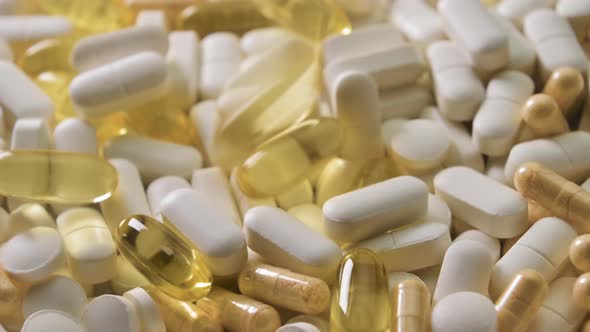 Different Pills with Capsules and Tablets Falling on White Table Concept of Medical Treatment Slow alt