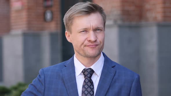 Thumbs Down By Businessman at Work Looking at Camera alt