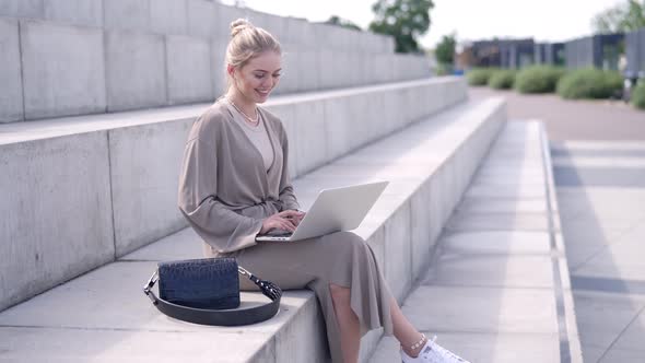 Stylish Woman Using Laptop on Street alt