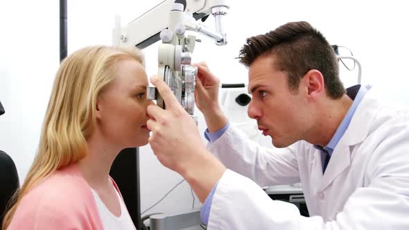 Optometrist examining female patient on phoropter alt